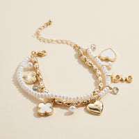 Layered Pearl Charm Bracelet – Love, Heart, and Clover Pendants